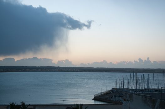 Cloud with rain sweeping out to sea in a winter morning in February, Can Pastilla, Majorca, Spain.