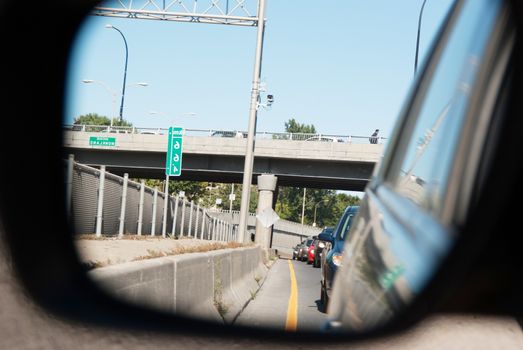 reflection in the mirror of a car, highway traffic congestion