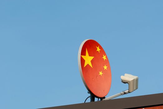 Chinese cable signal concept with flag overlaid the dish antenna on roof