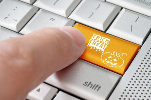 Trick or treat Halloween online concept on mettalic laptop keyboard