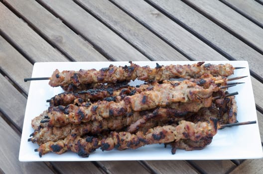 Vietnamese pork skewers plate on wooden table