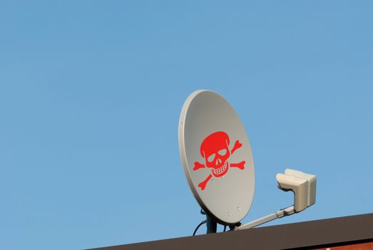 Hack concept Dish antenna with red skull sign on a roof