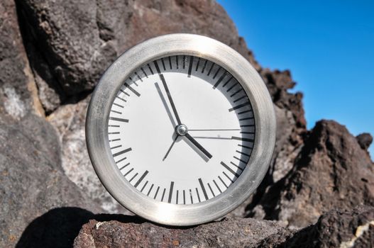 Time Concept Alarm Clock on the Volcanic Rocks