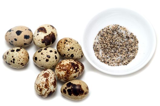 Eight quail eggs salt and pepper on white background
