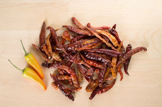 Dried red chili and yellow fresh chili on wooden cut board