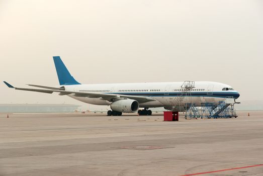 Commercial airline on platform airport during a cloudy day