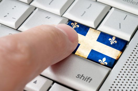 Business concept male finger pressing Quebec enter key on metallic keyboard