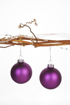 Two christmas balls hanging from branches. Modern christmas still life with copy space.
