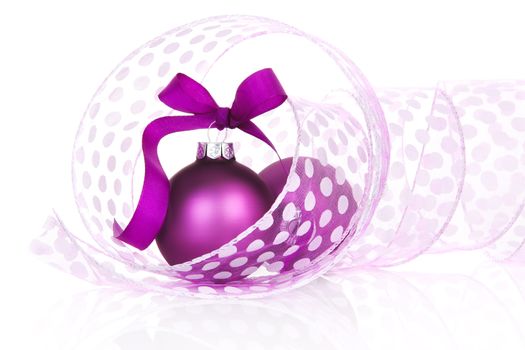 Temporary christmas still life in purple and white. Purple christmas balls with ribbon on white background.