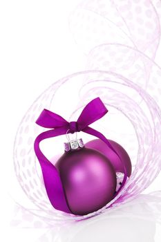 Temporary christmas background in purple and white. Purple christmas balls with ribbon on white background.