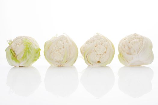 Four baby cauliflower isolated on white background with reflection. Healthy culinary vegetable. 