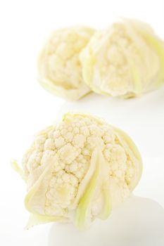 Raw baby cauliflower on white background. Culinary healthy vegetable concept.