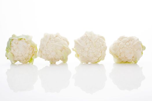 Four baby cauliflower isolated on white background with reflection. Healthy culinary vegetable. 