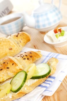 Luxurious delicious breakfast background. Croissatn with fresh vegetable, tea and financial times in background. Good morning concept.