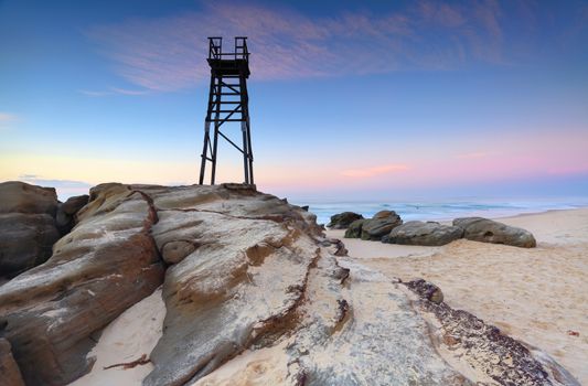 A bird sits on the shark tower at Redhead Beach, NSW Australia at dawn