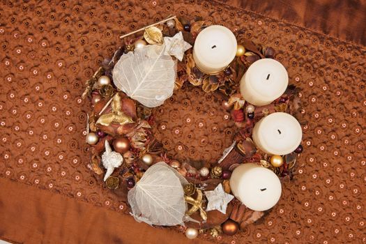 Traditional handmade brown christmas wreath on luxurious tablecloth. Traditional christmas concept.