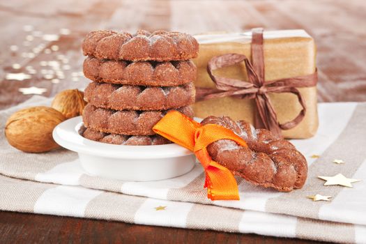 Christmas chocolate cookies with ribbon, stars and nuts. Festive holiday background.