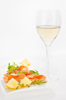 Luxurious dining. White wine with fresh raw salmon with fresh herbs and lemon.
