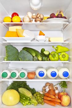 Full fridge of fruits, vegetables and diary products. Fresh healthy fitness eating concept.