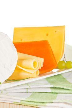 Luxurious cheese variation on white tray on kitchen cloth. Luxurious culinary eating.