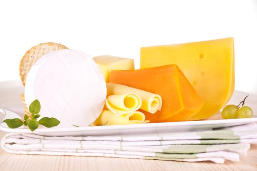 Luxurious cheese collection on white tray on kitchen cloth. Luxurious culinary eating.