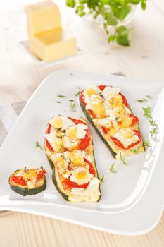 Delicious baked zucchini slices with tomato, cheese and thyme. Culinary vegetarian light eating.