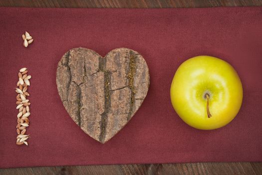 I love apple made of grain, wooden heart and green fresh apple. Healthy eating background.