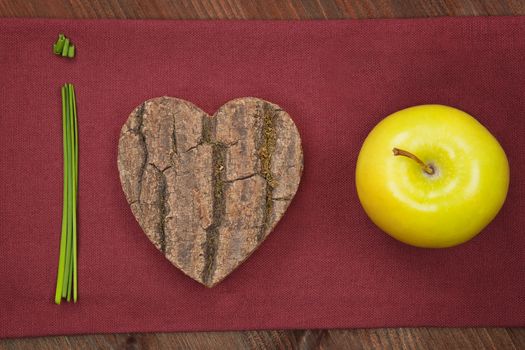 Healthy eating. Love fruits and vegetable made from chive, wooden heart and green fresh apple.