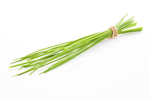 Organic chive bound with brown natural rope isolated on white background. Culinary aromatic herb.