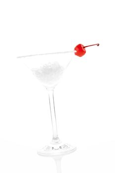 Luxurious cocktail glass with ice and cherry garnish isolated on white background. Summer drink.