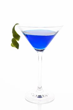 Blue luxurious delicious cocktail with lime garnish in cocktail glass isolated on white background. Fresh summer drink.