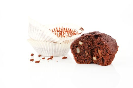  Chocolate muffin cross section isolated on white. Paper and crumbs in background.