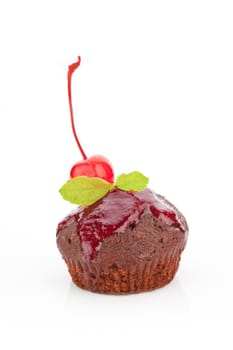 Delicious chocolate muffin with marmalade and cherry garnish isolated on white background.