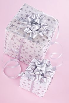 Beautifully wrapped christmas gifts on pink background. Christmas background.