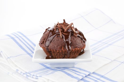 Luxurious chocolate muffin decorated with chocolate. Delicious sweet food concept.