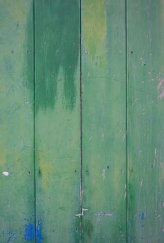 Green vintage door with grungy and shabby look in green, blue and yellow.