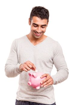 Beautiful man saving money to a piggy bank