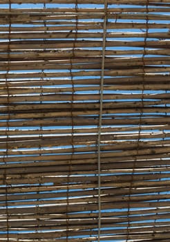 Bamboo shade as sun protection and blue sky.