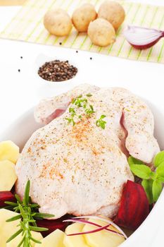 Delicious chicken with fresh herbs and vegetable in baking dish prepared for baking. Poultry.