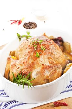 Golden baked chicken with vegetables and fresh herbs in baking dish ready for eating. Culinary eating.