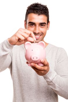 Beautiful man saving money to a piggy bank