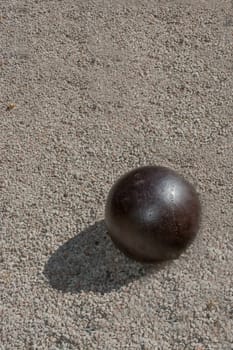 Iron ball on gravel with shadow