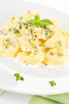 Tortellini pasta with white cream sauce and herbs. Traditional italian pasta.