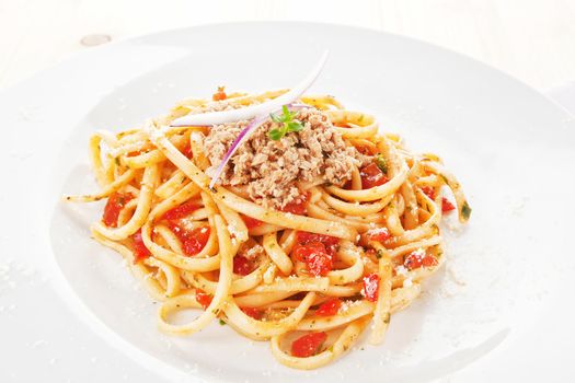 Delicious spaghetti with tomato sauce, tuna and fresh herbs. Traditional italian cuisine.