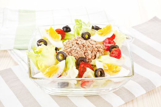 Delicious colorful tuna salad with tomatoes, olives and eggs. Fresh summer salad.