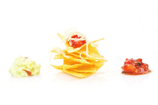 Nachos with cheese and tomato and guacamole dip isolated on white. Mexican eating.