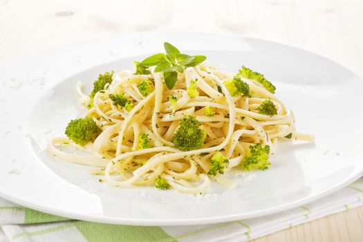 Spaghetti carborana with broccoli and fresh herbs on white plate. Traditional italian cuisine.