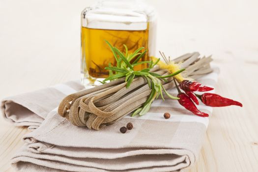 Italian traditional pasta with herbs and olive oil background.