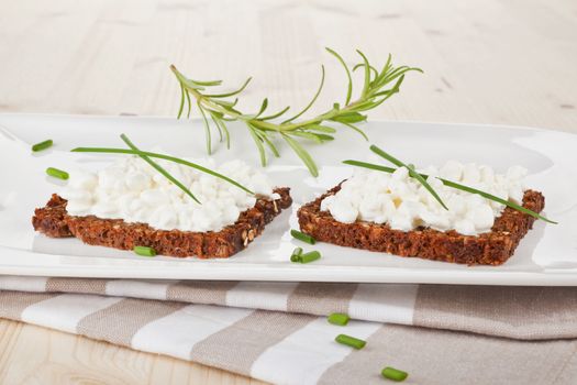 Luxurious black bread slices with cottage cheese on white plate. Healthy eating. 