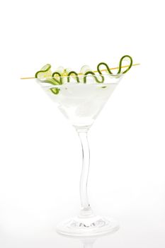 Delicious white coctail with ice and cucumber garnish in cocktail glass isolated on white. 